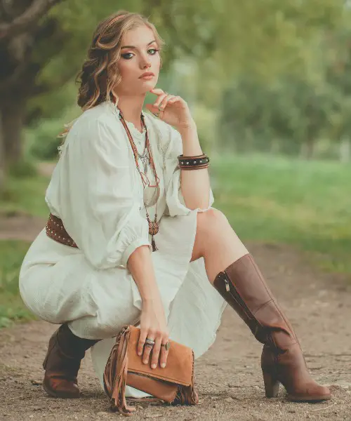 A woman wears brown boots and white dress