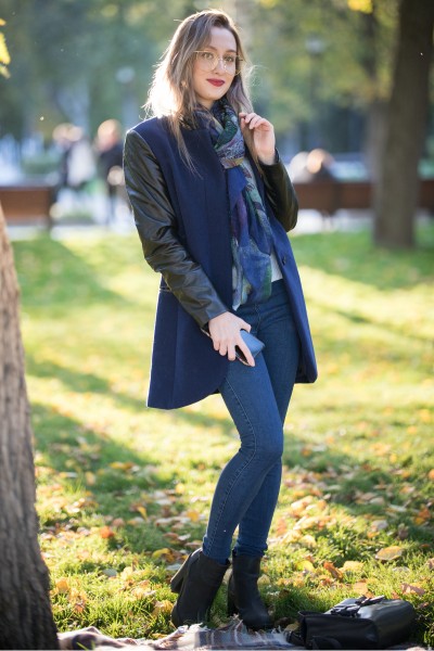 A woman wears jeans, coat and a pair of black ankle cowboy boots