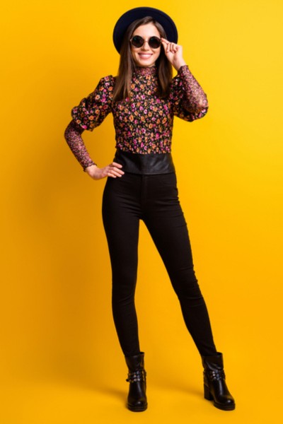 A woman wears legging, boots with floral top