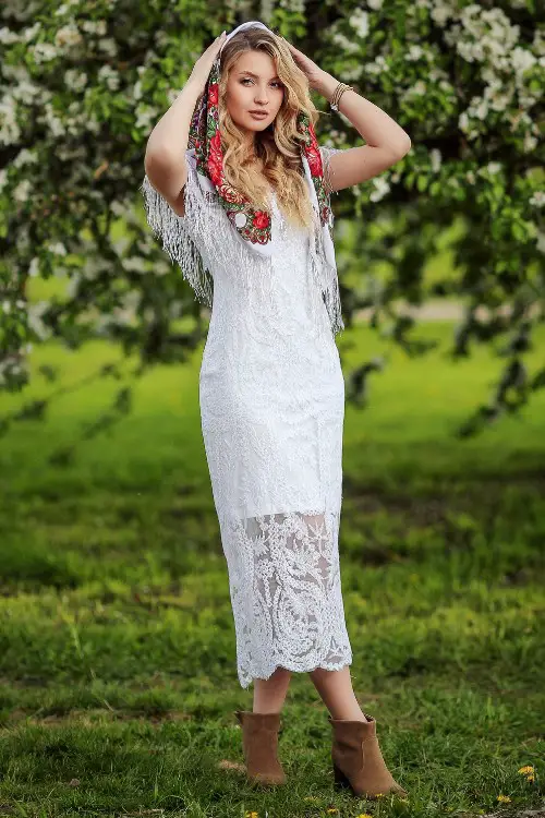 A woman wears long lace dress with suede ankle boots