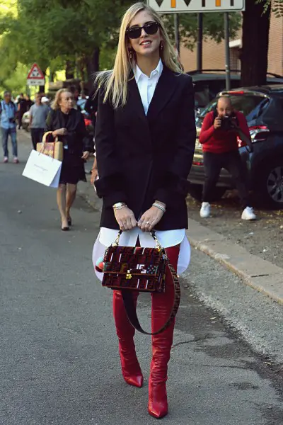 A woman wears red cowboy boots with blazer and shirt