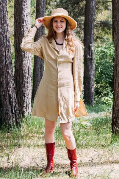 A woman wears red cowboy boots with button front dress