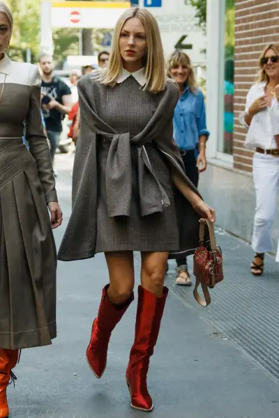 A woman wears red cowboy boots with dress