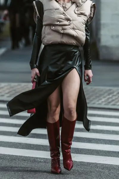 A woman wears red cowboy boots with split leather dress and coat