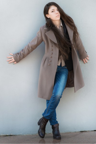 A woman wears short boots with jeans and blazer