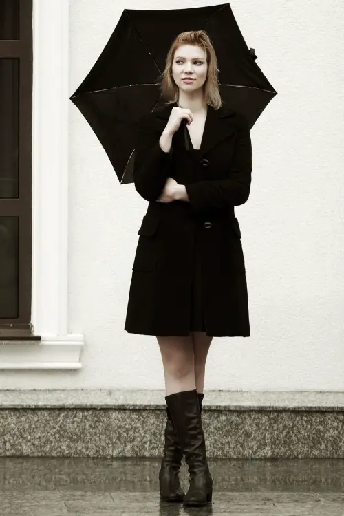 A woman wears tall cowboy boots with black dress