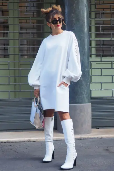 A woman wears white cowboy boots with a white dress