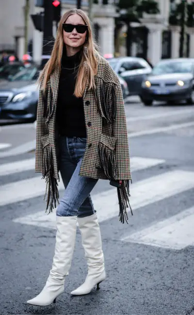 A woman wears white cowboy boots with jeans