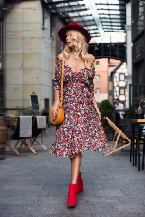 a woman wears midi floral dress with red ankle cowboy boots