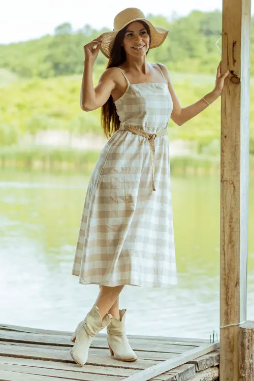 A woman wears akle cowboy boots with midi dress