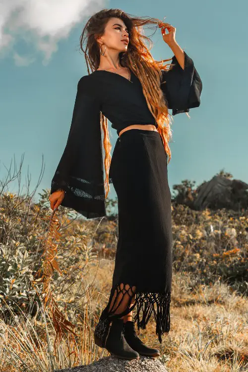 A woman wears ankle cowboy boots with a boho dress