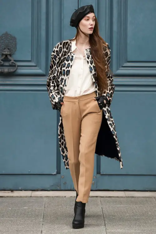 A woman wears black cowboy boots with beige pants