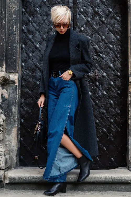 A woman wears black cowboy boots with denim skirt