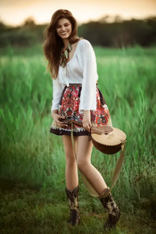A woman wears black cowboy boots with light shirts and a boho skirt