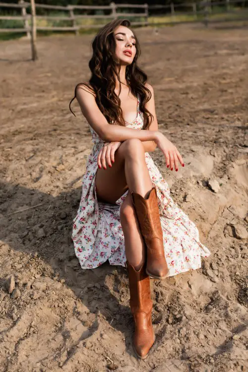 A woman wears brown cowboy boots with 2 straps floral dress