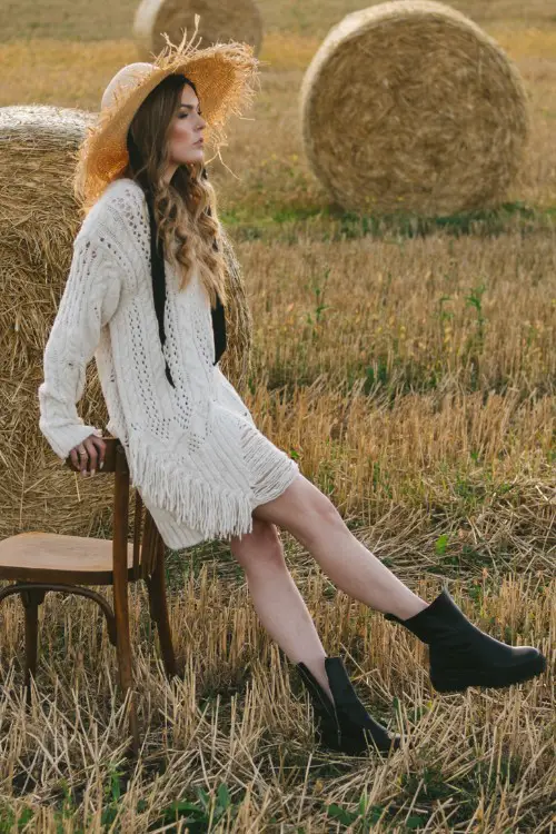 A woman wears cowboy boots with a country dress