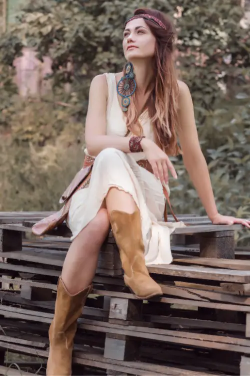 A woman wears cowboy boots with dress in Boho style