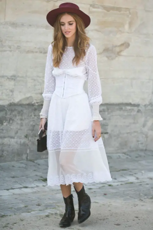 A woman wears cowboy boots with white dress