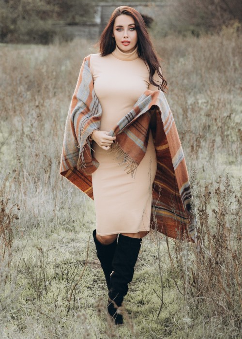 A woman wears fitted dress with suede cowboy boots