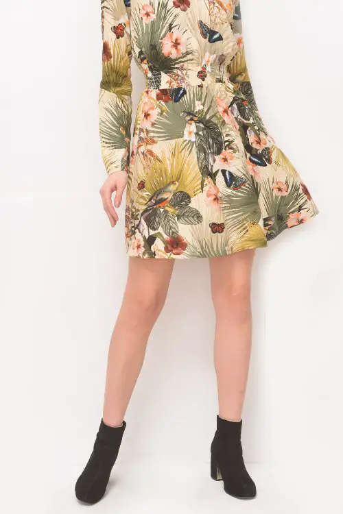 A woman wears floral dress with ankle cowboy boots