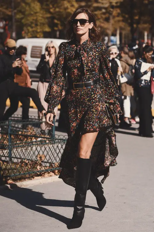 A woman wears floral dress with black cowboy boots