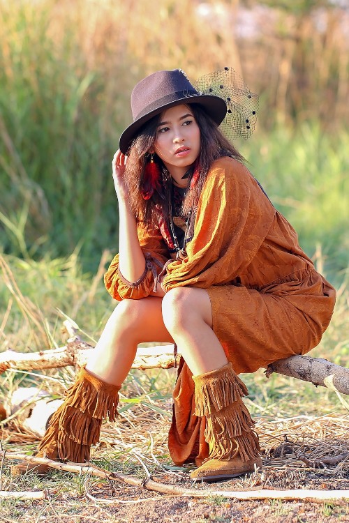 A woman wears fringed cowboy boots with country dress