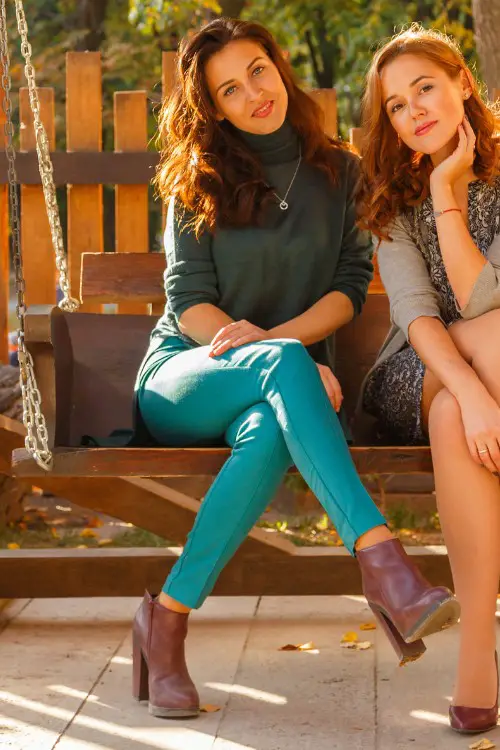 A woman wears jeans, fitted top and ankle cowboy boots