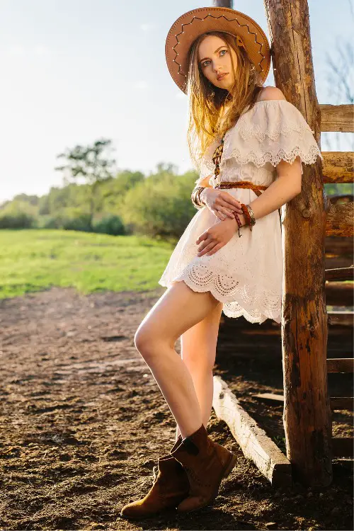A woman wears lace dress with cowboy boots