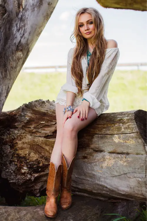 A woman wears lace short, top and a pair of brown cowboy boots