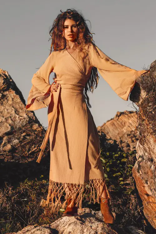 A woman wears long dress with suede cowboy boots