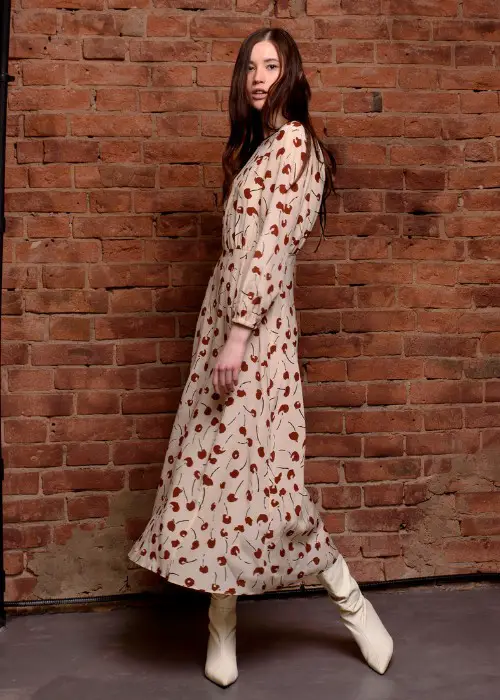 A woman wears midi dress with white cowboy boots