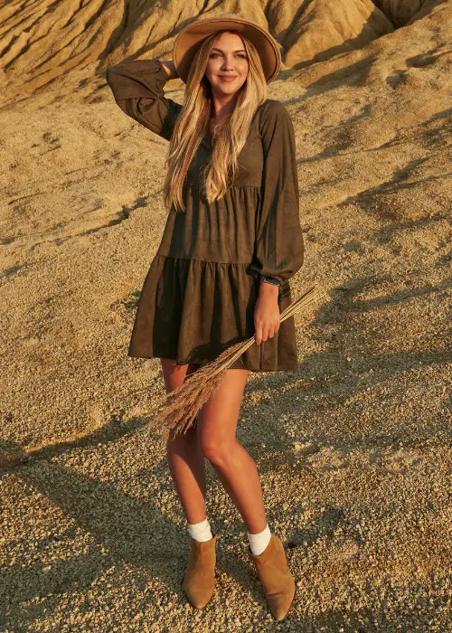 A woman wears mini dress with ankle suede cowboy boots