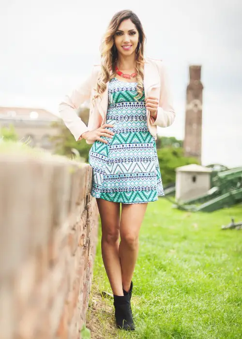 A woman wears partened dress with ankle cowboy boots