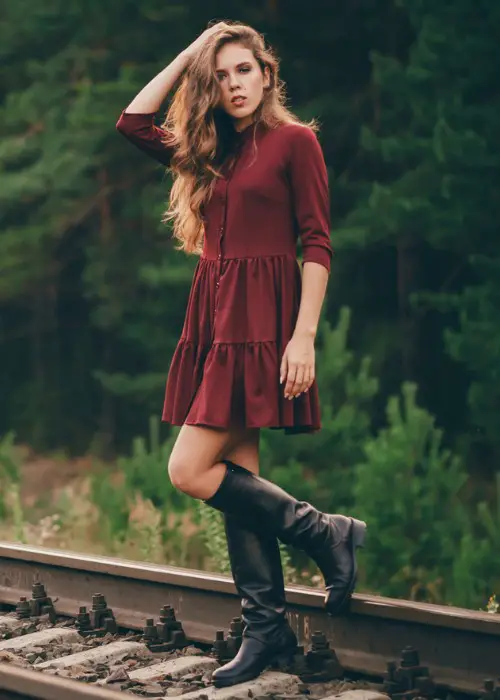 A woman wears red dress with black cowboy boots