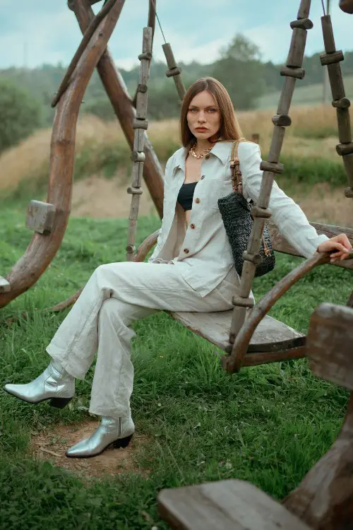 A-woman-wears-silver-cowboy-boots-with-a-beige-suits