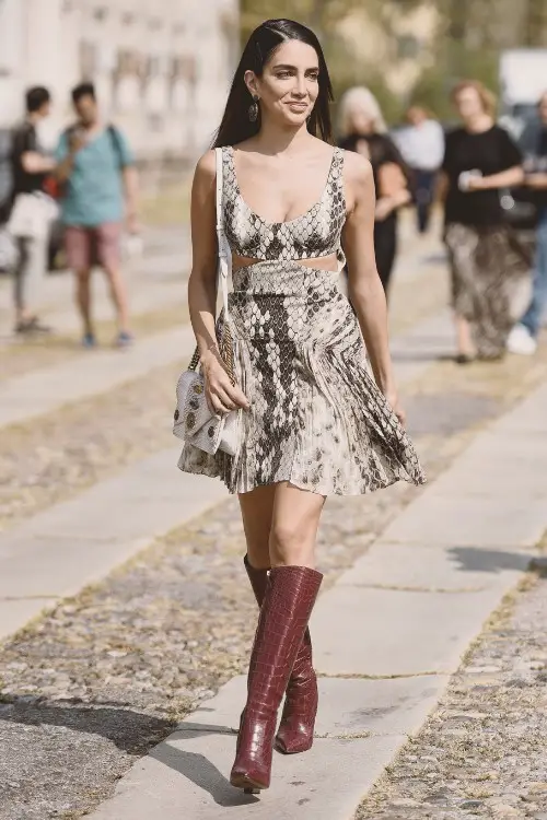A woman wears snakeskin print dress with cowboy boots