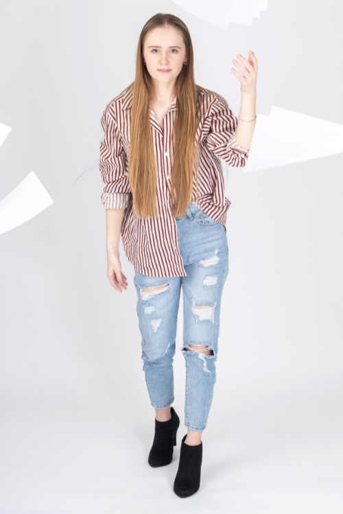 A woman wears stripped top, jeans and ankle cowboy boots