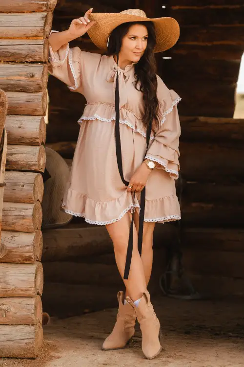 A woman wears tiered dress with cowboy boots