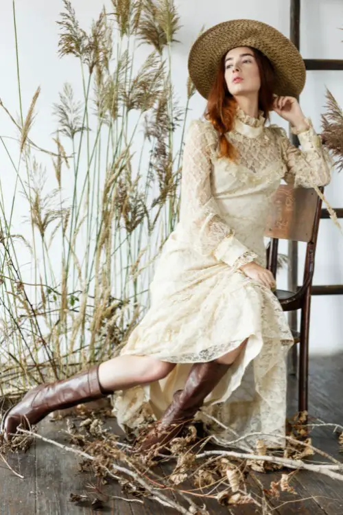 A woman wears wedding dress with brown cowboy boots