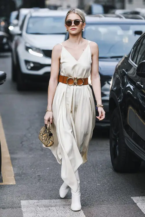 A woman wears white cowboy boots with 2 straps dress