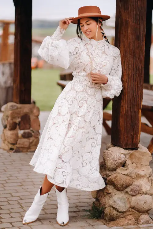 A-woman-wears-white-cowboy-boots-with-white-dress-and-a-cowboy-hat