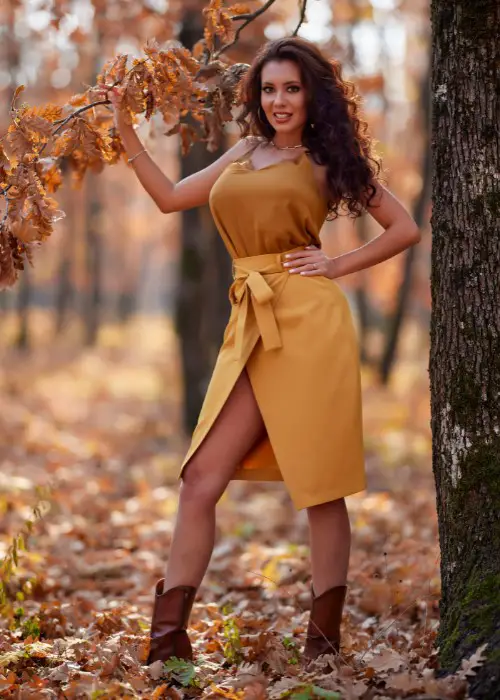 A woman wears wrap dress with ankle cowboy boots