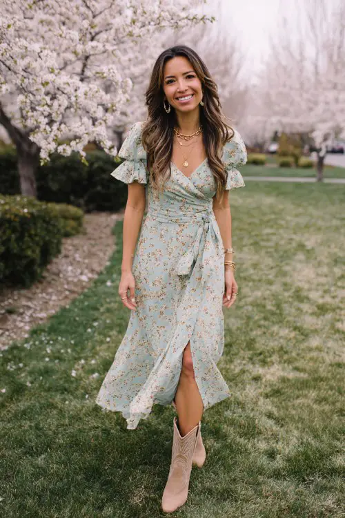 A woman wears a soft floral midi dress in pastel tones with flutter sleeves, paired with light brown cowboy boots