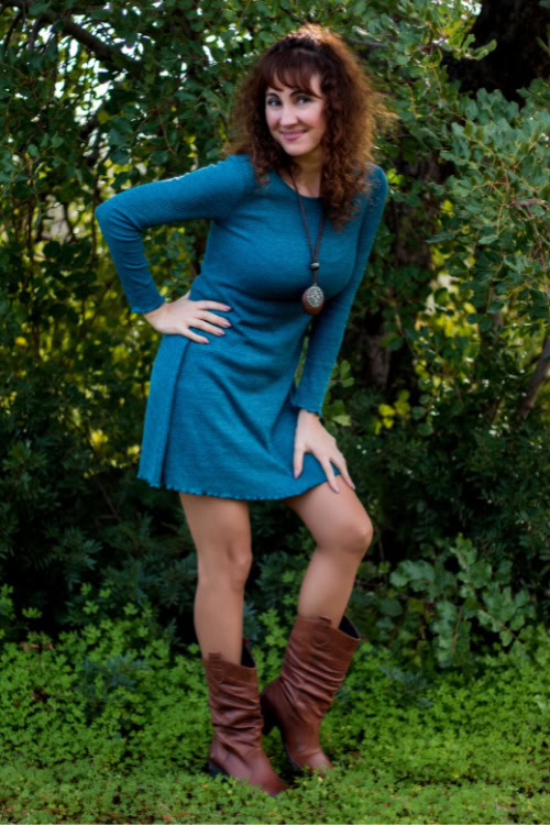 A woman wears cowboy boots with a blue dress
