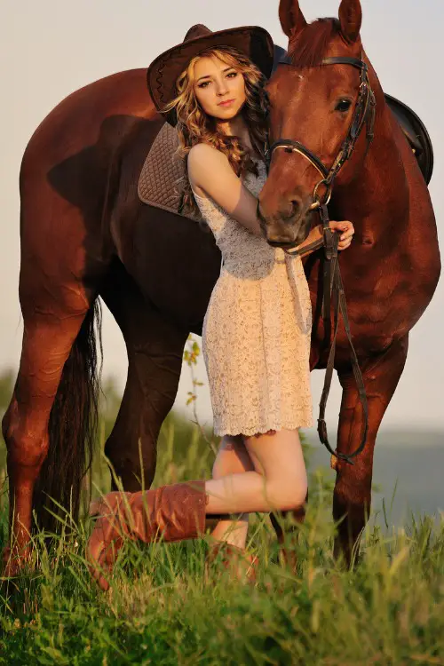 A woman wears cowboy boots with a lace dress