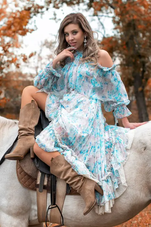 A woman wears cowboy boots with a ruffle dress