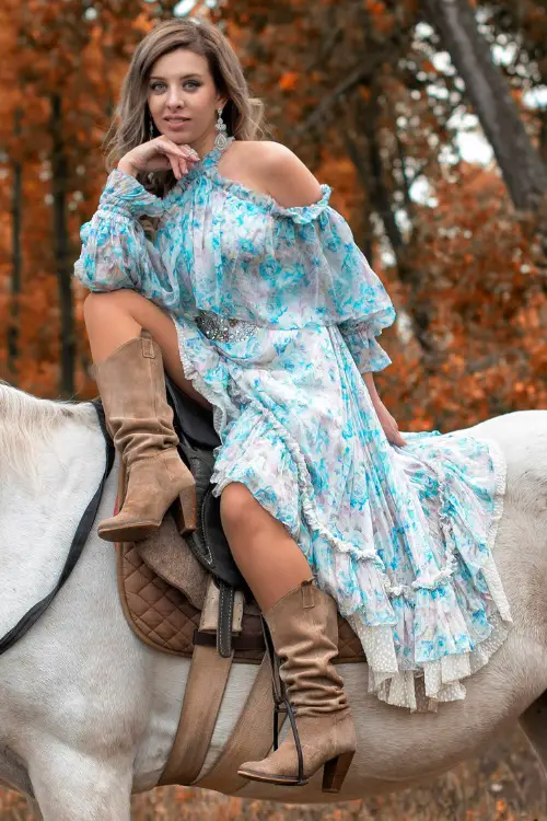 A woman wears cowboy boots with a ruffle dress