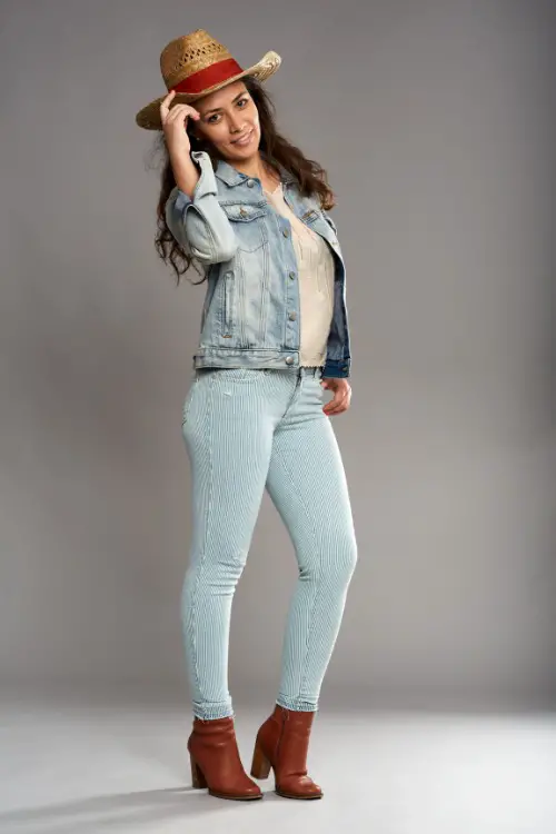 a woman wears cowboy boots with skinny jeans and a white top