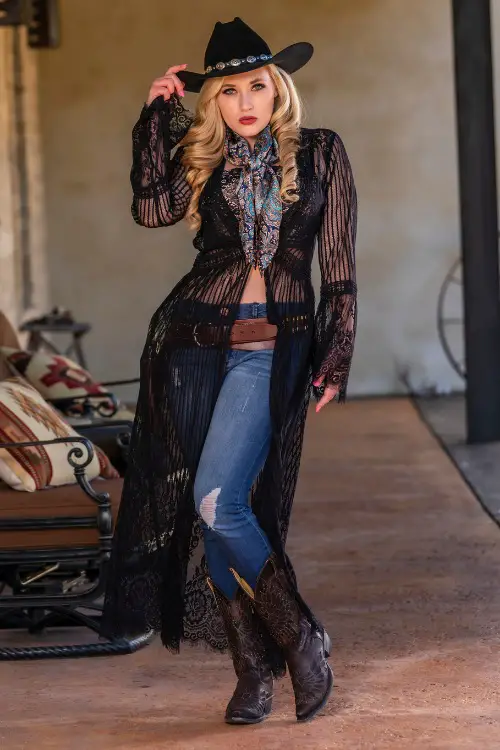 A woman wears a brown cowboy boots with jeans and a sheer top