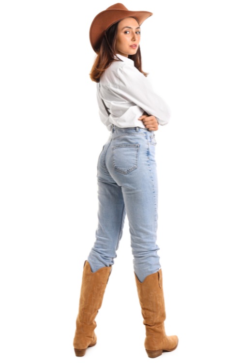 a woman wears cowboy boots with jeans and a white shirt